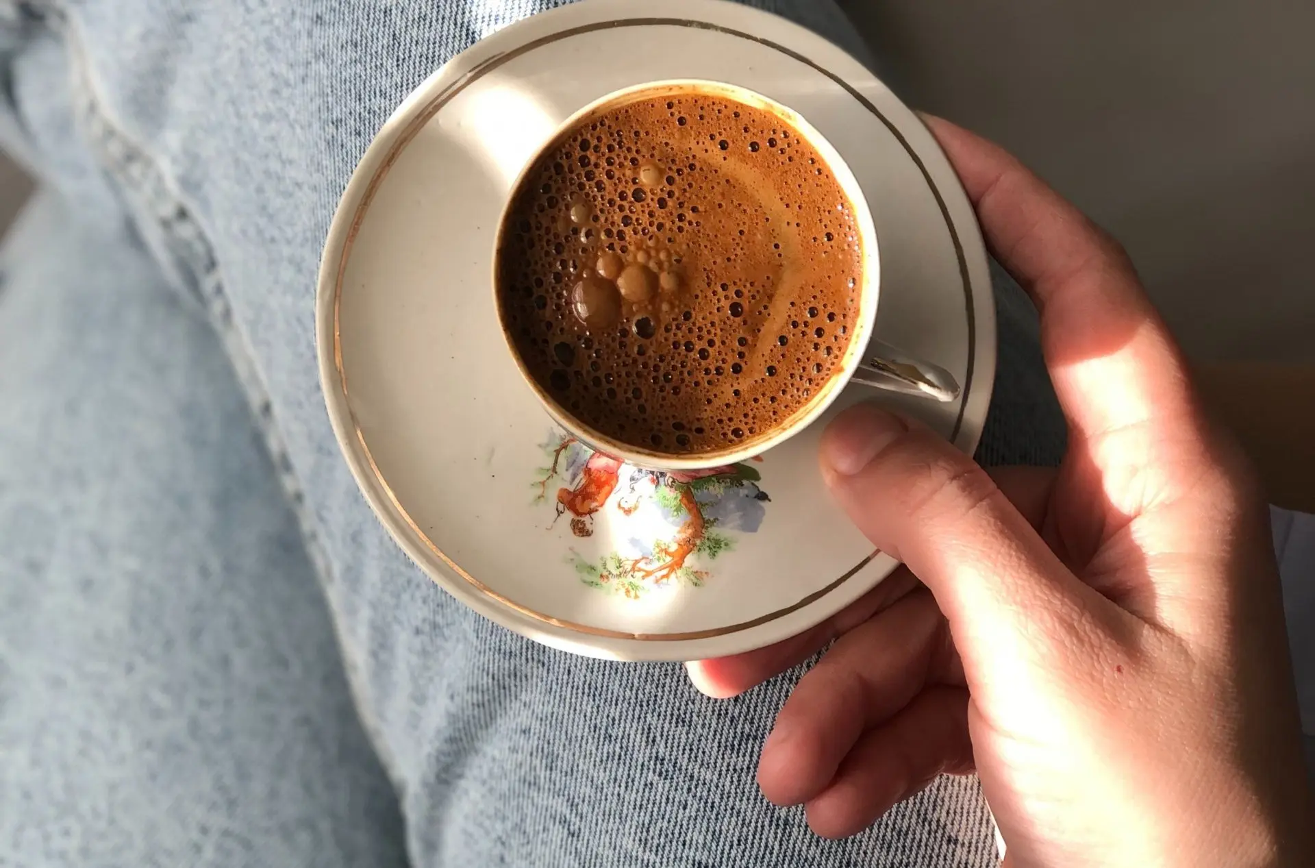 Blommig kaffekopp i knäet.