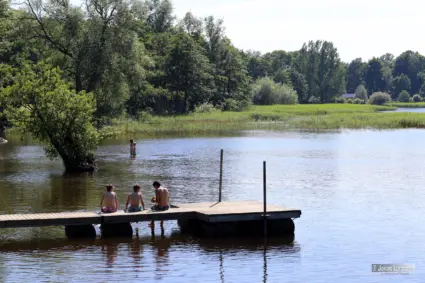 barn som sitter på en brygga vid en sjö