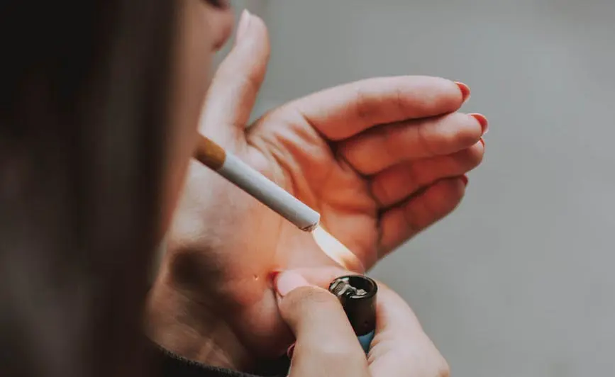 Foto: En kvinna tänder en cigarett