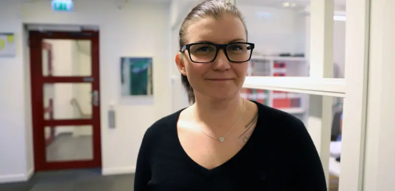 Halvbildsporträtt av kvinna i kontorslokal.
