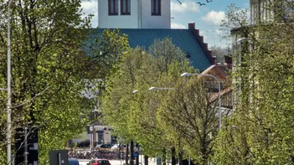 gata med bilar och längs vägen och en kyrka i bakgrunden