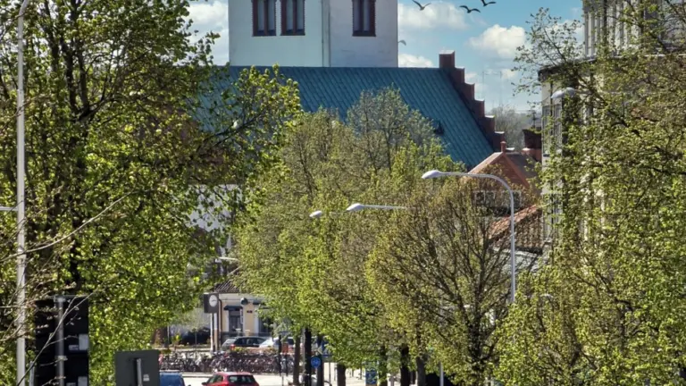 gata med bilar och längs vägen och en kyrka i bakgrunden