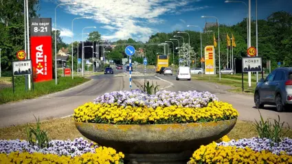 blomsterarrangemang i rondell vid en väg