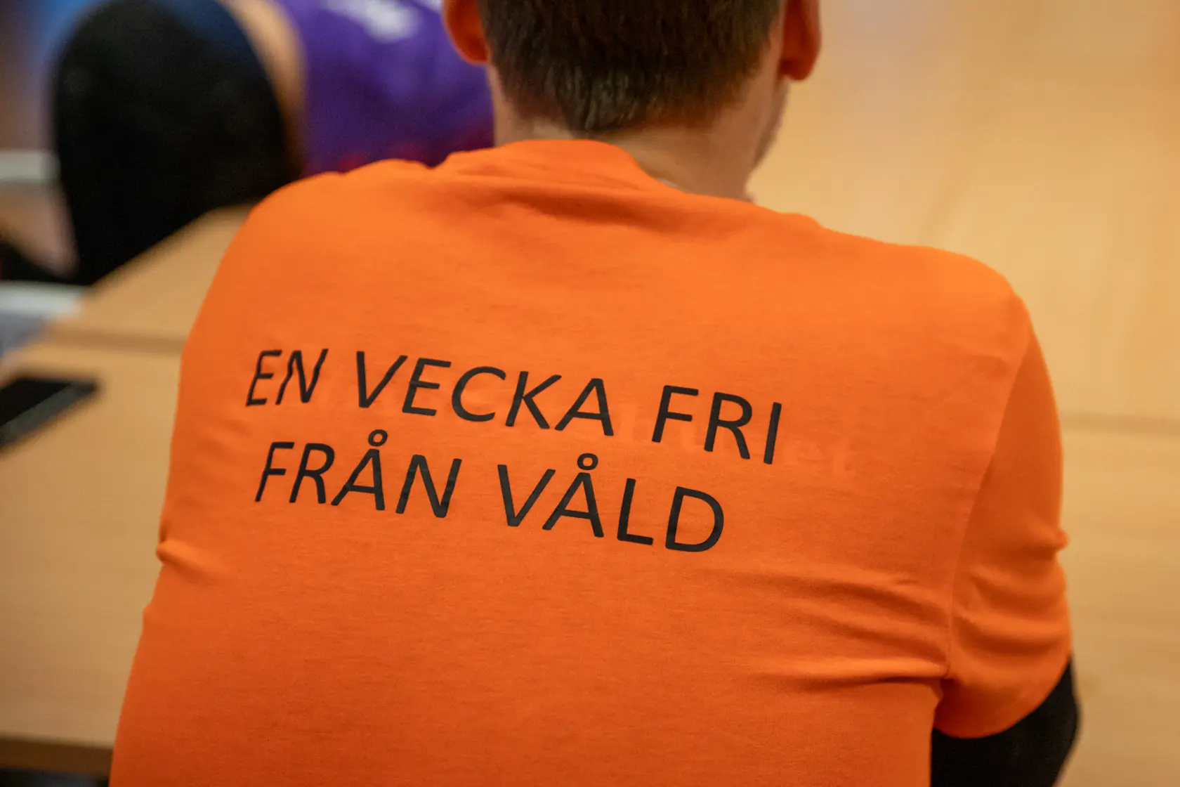 En bild på en ryggtavla som har på sig en orange t-shirt med texten "En vecka fri från våld" tryckt